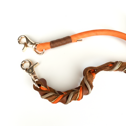 Close-up of hand-stitched 4mm full-grain leather details and reinforced orange braided rope on a premium dog leash.