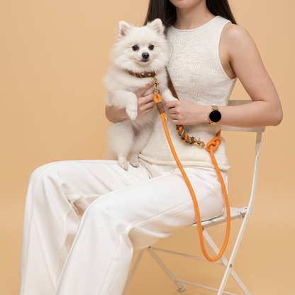 A person using the 6-in-1 dog leash in hands-free shoulder mode, attached to an Orange Tan hand-braided collar.
