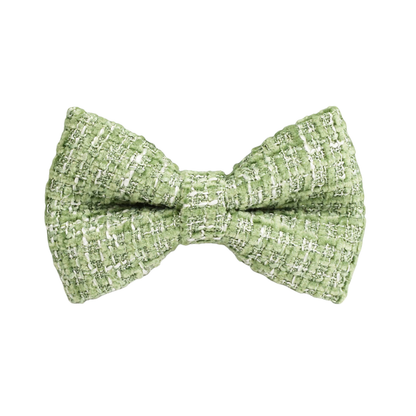 Close-up of a Bling Fuzzie sage green tweed detachable dog bow tie, showing the classic woven texture with white thread details on a white background