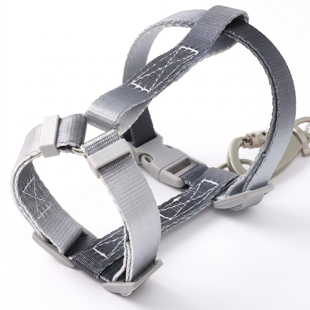 Close-up of a Bling Fuzzie grey black escape-proof H-style step-in cat harness, showing the adjustable straps, dual-lock buckle, and zinc alloy clasp on a white background