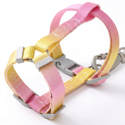 Close-up of a Bling Fuzzie pink yellow escape-proof H-style step-in cat harness, showing the adjustable straps, dual-lock buckle, and zinc alloy clasp on a white background