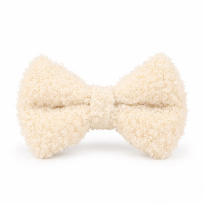 Close-up of an ivory teddy fleece detachable dog bow tie featuring soft, curly fabric and a classic bow shape.