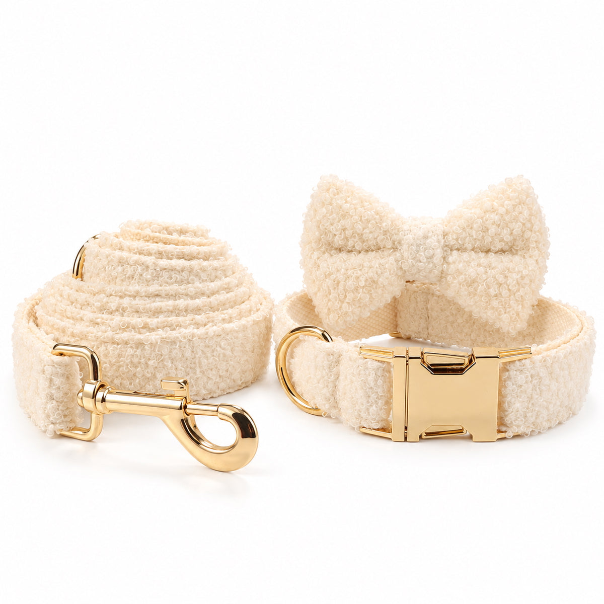 Ivory teddy fleece dog collar with detachable bow tie and matching leash, featuring gold-tone hardware on a white background.