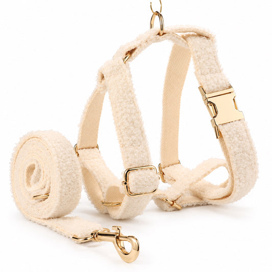 Ivory teddy fleece adjustable dog harness with matching leash and gold-tone metal hardware.