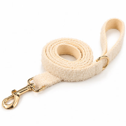 Ivory teddy fleece dog leash with a gold-tone swivel clip, matching handle and soft curly texture.