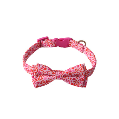 Pink and coral heart leopard print dog collar with removable bow tie and plastic safety buckle on white background - stylish pet accessory