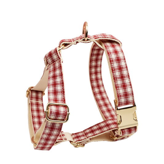 Red and cream plaid adjustable dog harness with gold metal buckles, adjustable straps and cream-colored lining.