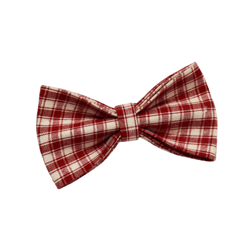 Close-up of red and cream plaid dog bow tie showing its classic check pattern and fabric texture.