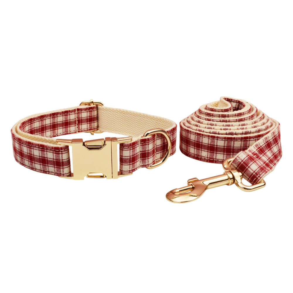 Adjustable red and cream plaid dog collar with gold buckle and matching leash displayed on a white background.