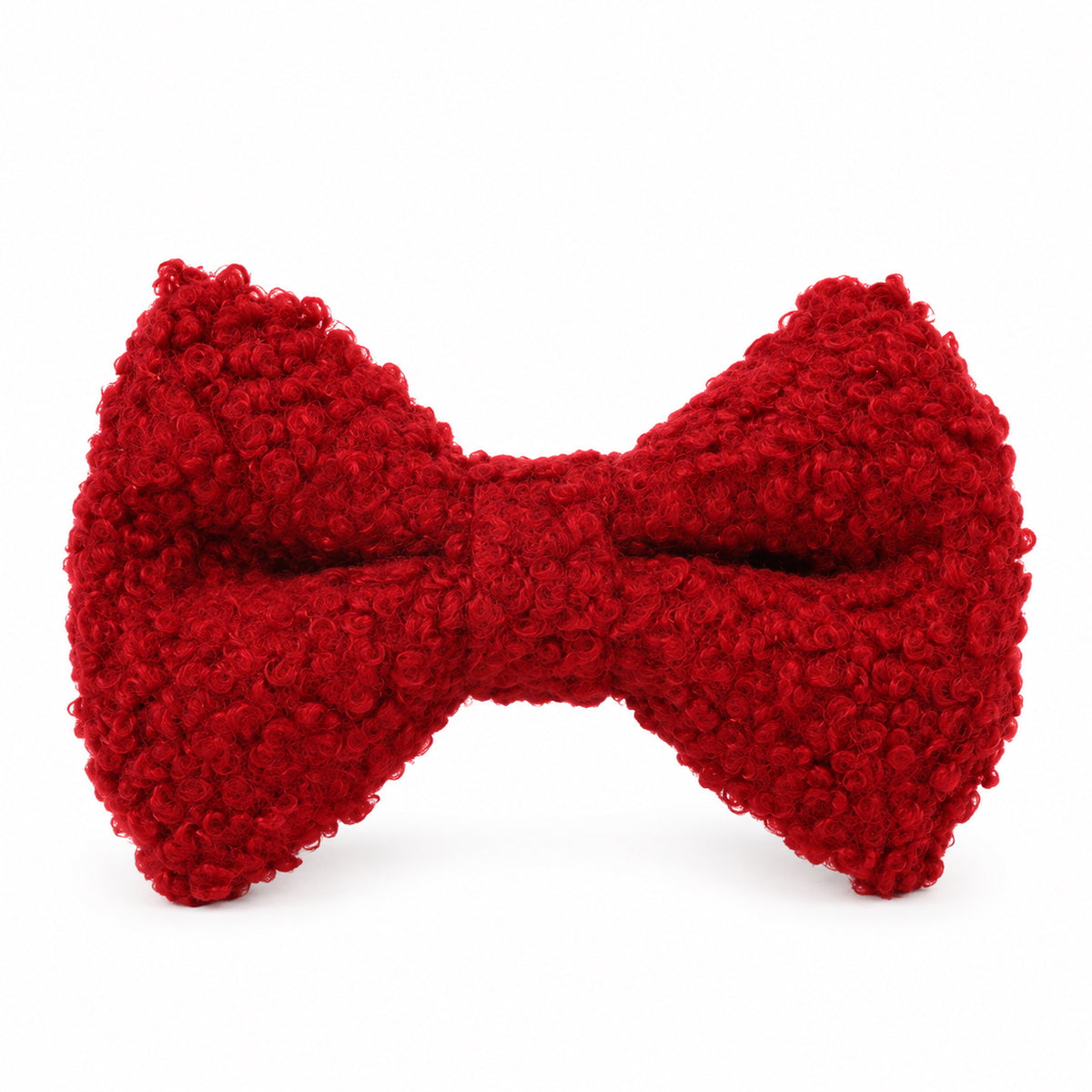 Close-up of a red teddy fleece dog bow tie featuring soft, curly textured fabric on a white background.